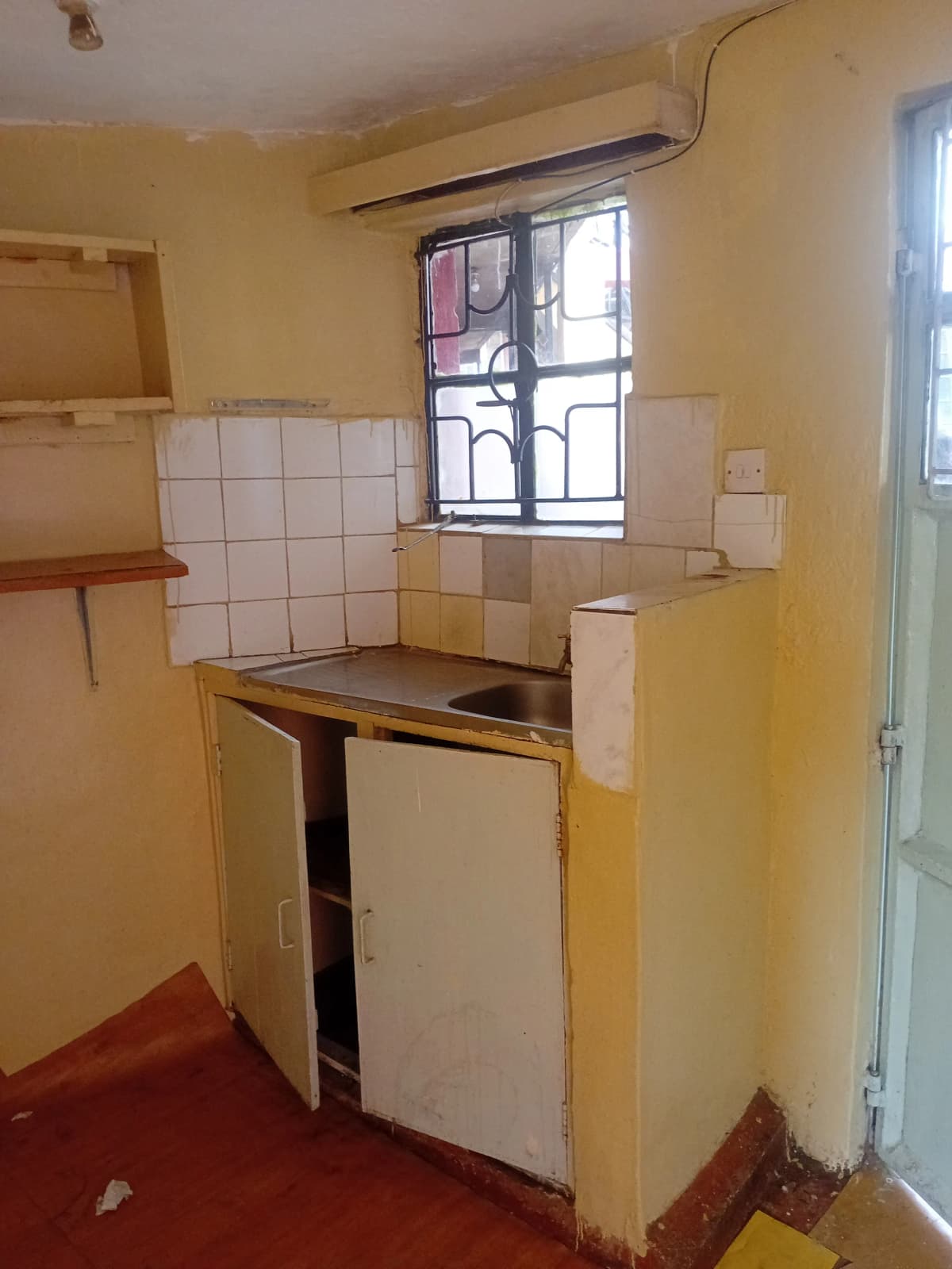 Compact kitchen with white tile backsplash and single window