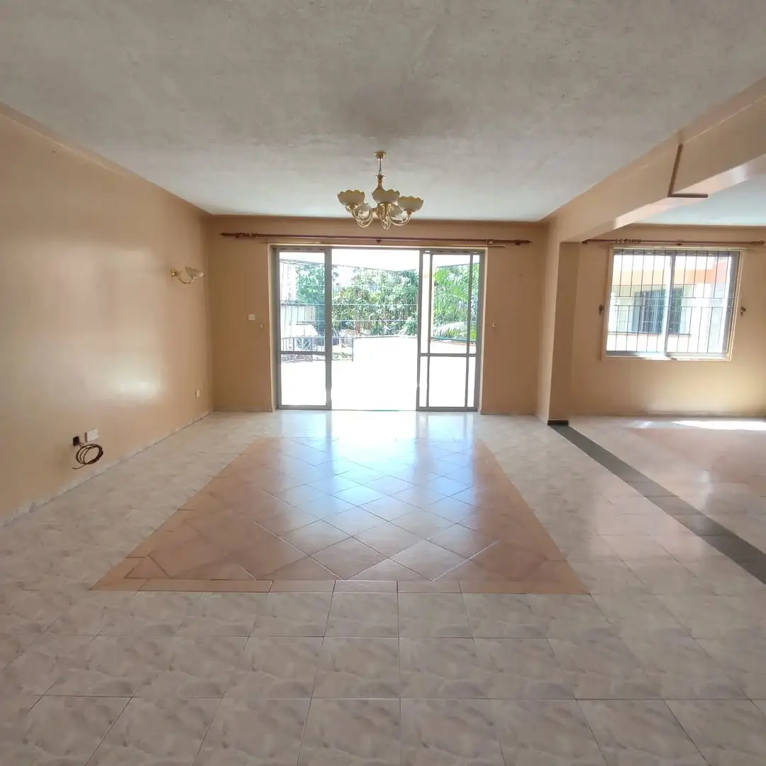 Spacious open-plan living area with marble flooring and glass doors