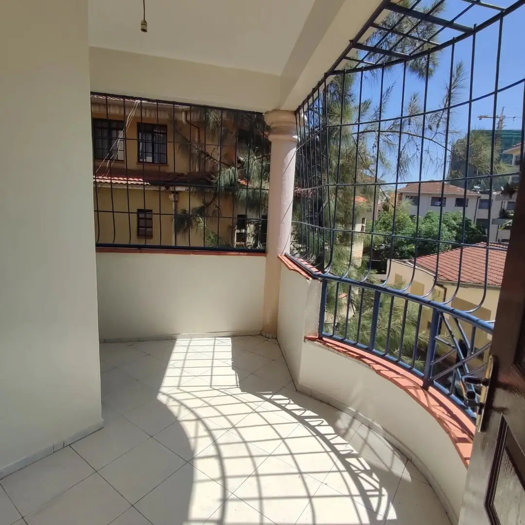 Bright covered balcony with railing, city views, tiled flooring