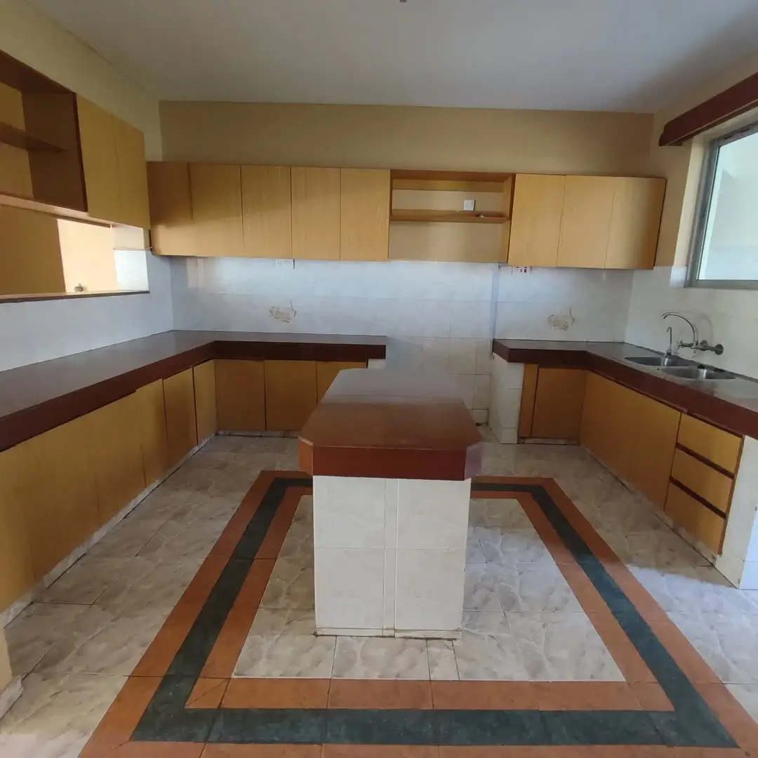 Spacious U-shaped kitchen with wooden cabinets and marble counters