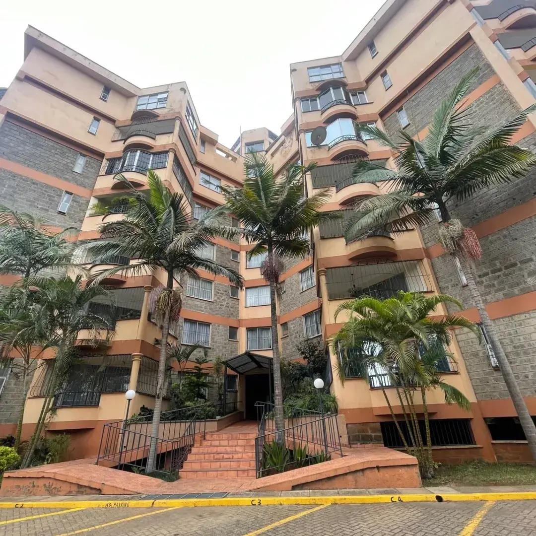 Multi-story residential building with terra-cotta facade and palm trees