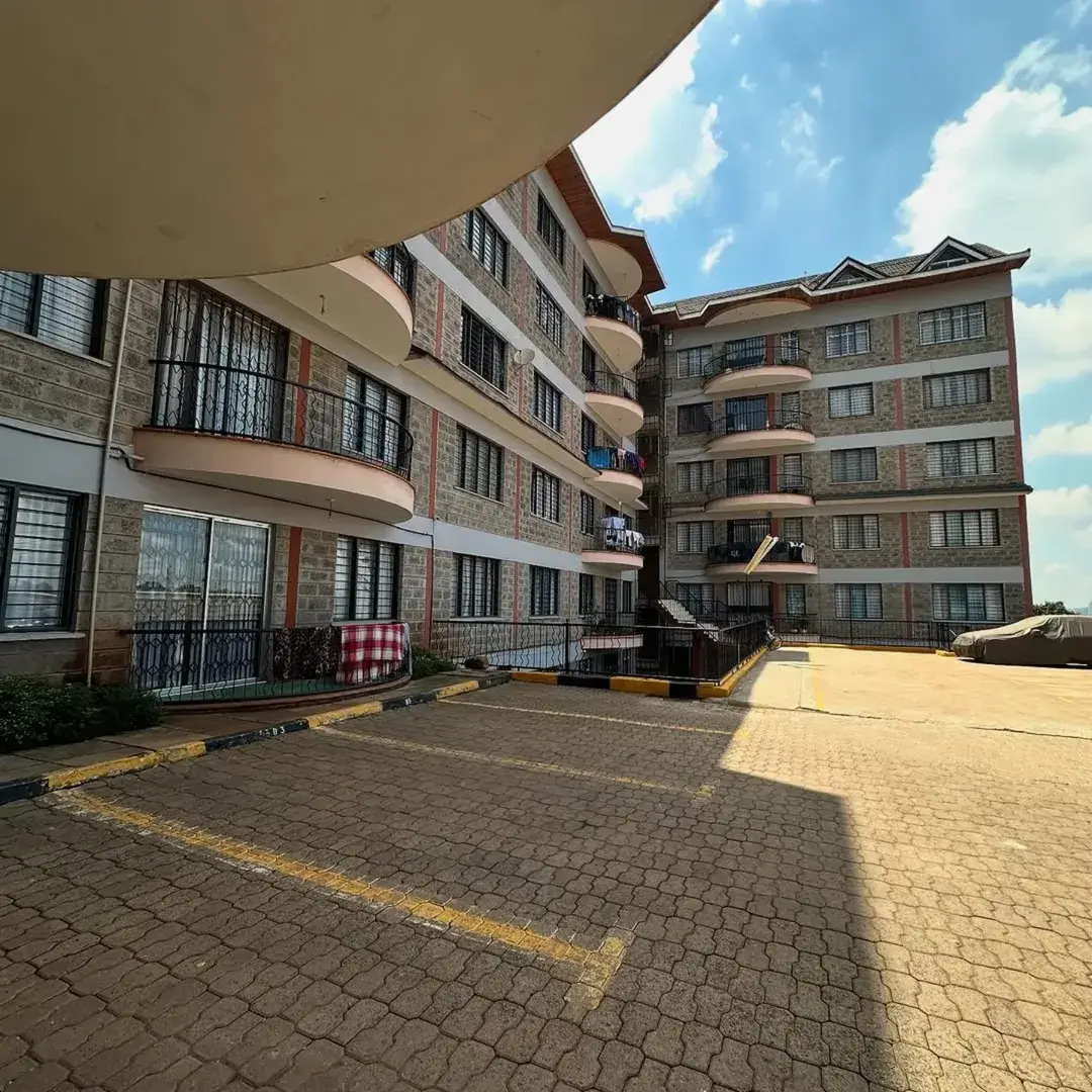 Multi-story residential compound with paved courtyard and parking area