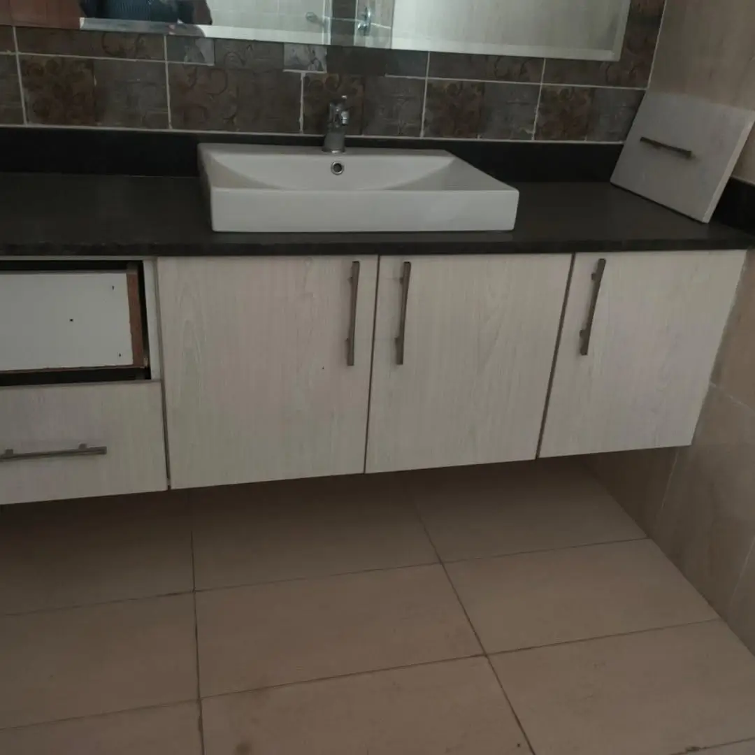 Modern bathroom vanity with rectangular sink and dark backtile