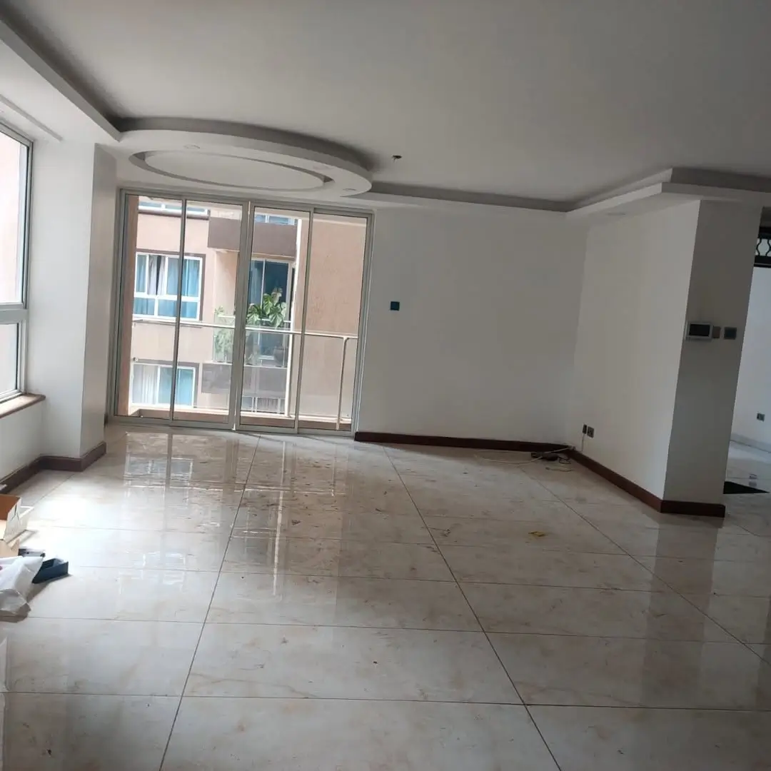 Spacious open-plan living area with large glass doors and balcony access