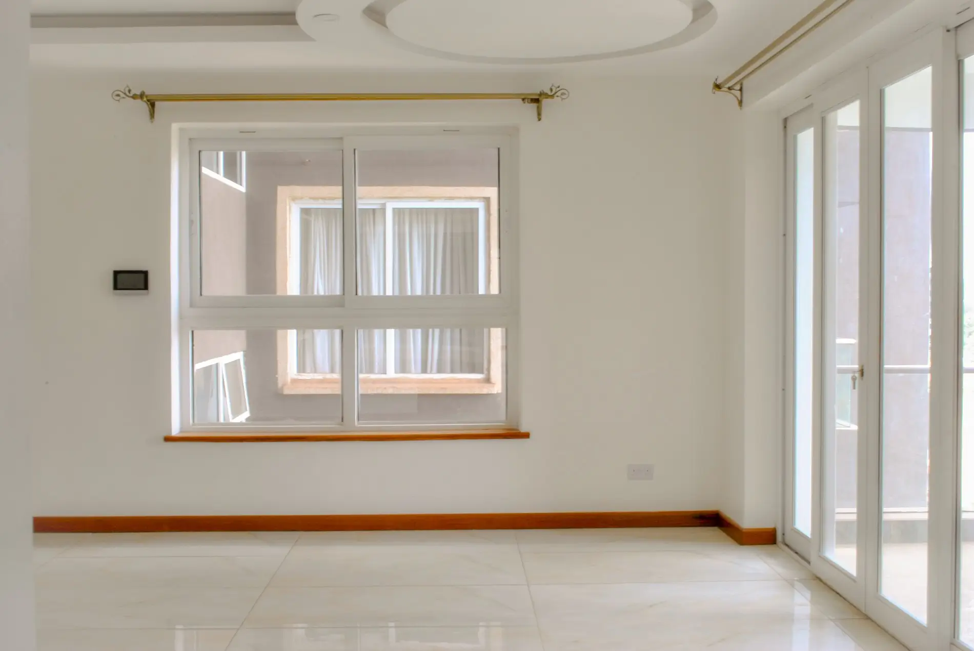 Bright empty living space with large windows and glass doors