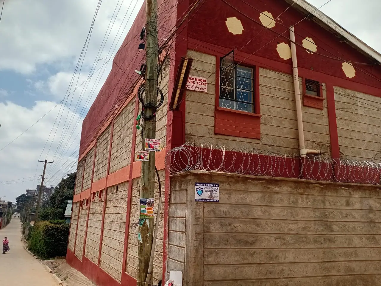 Red brick building facade with barbed wire security fencing