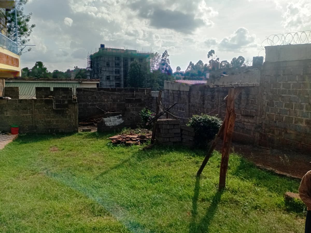 Spacious compound grounds with lush grass and perimeter walls