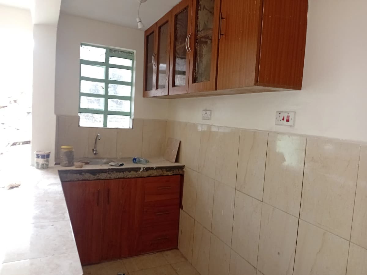 Compact kitchen with red cabinetry and beige tile backsplash