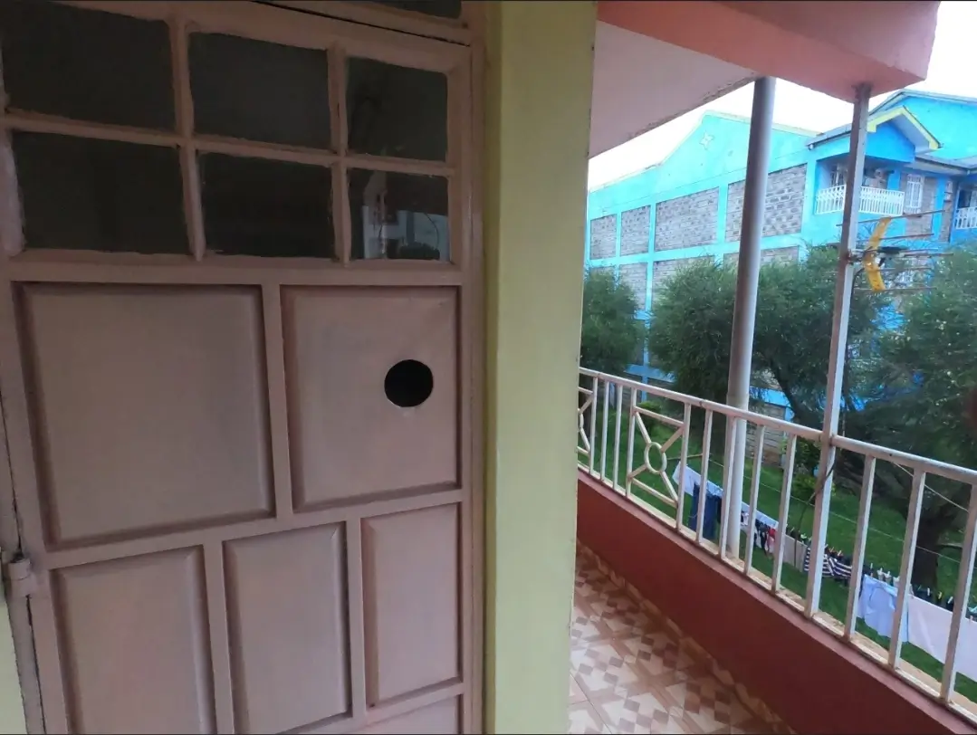 Covered balcony with white railings and compound views