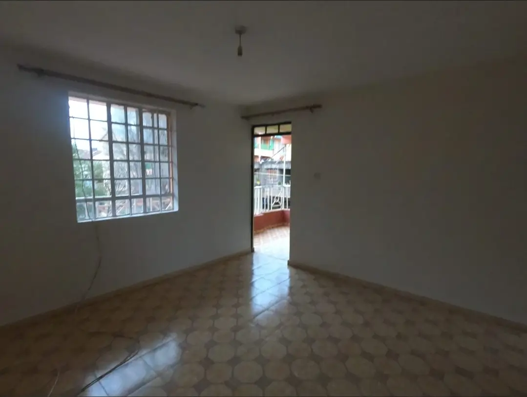 Spacious living room with natural light from barred window