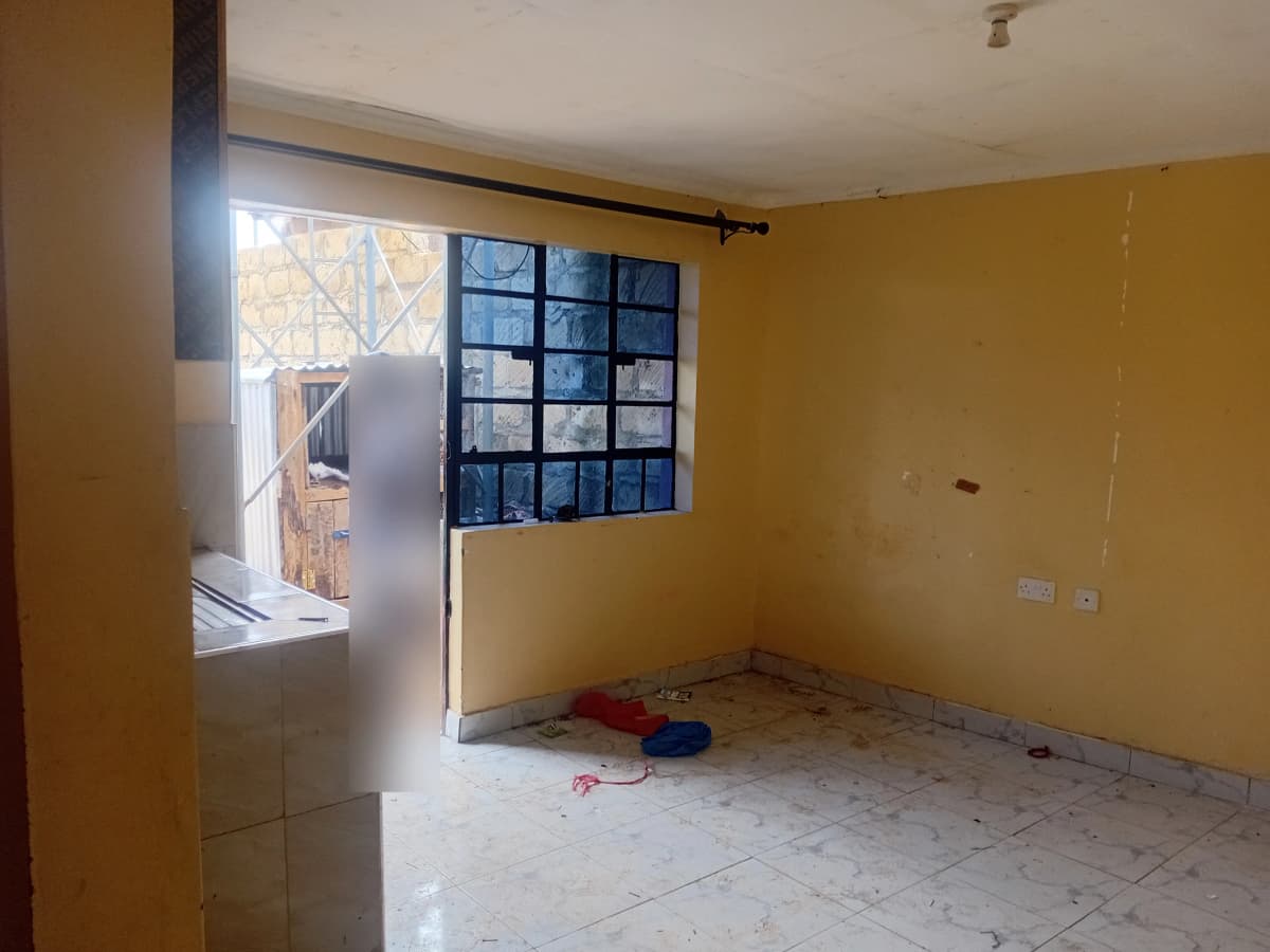 Unfurnished living room with yellow walls and barred windows