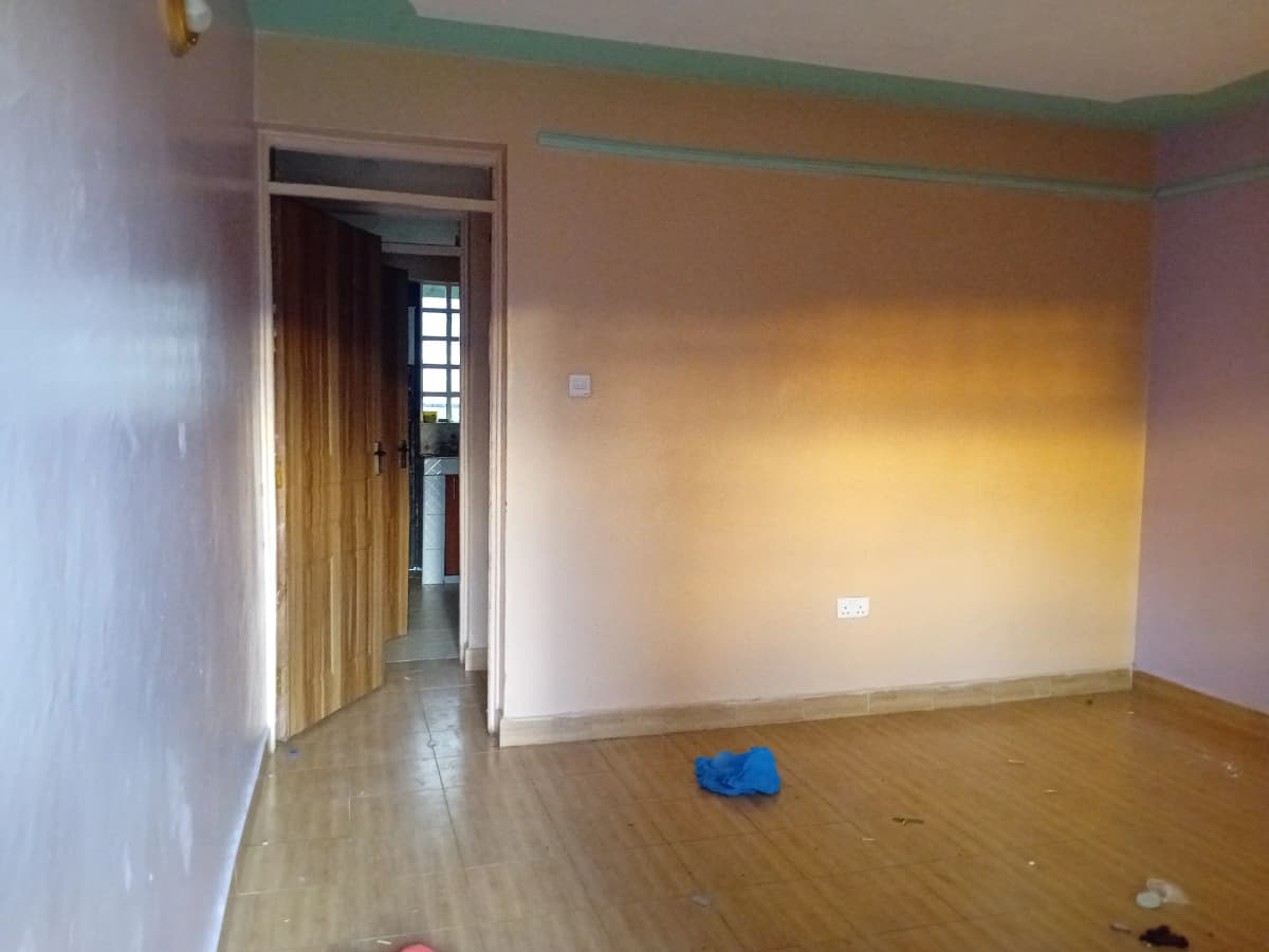 Empty living room with yellow walls and wooden flooring