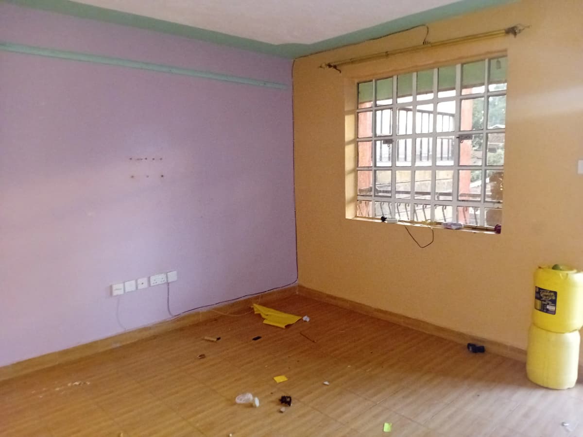 Empty bedroom with pink and yellow walls, wooden floor