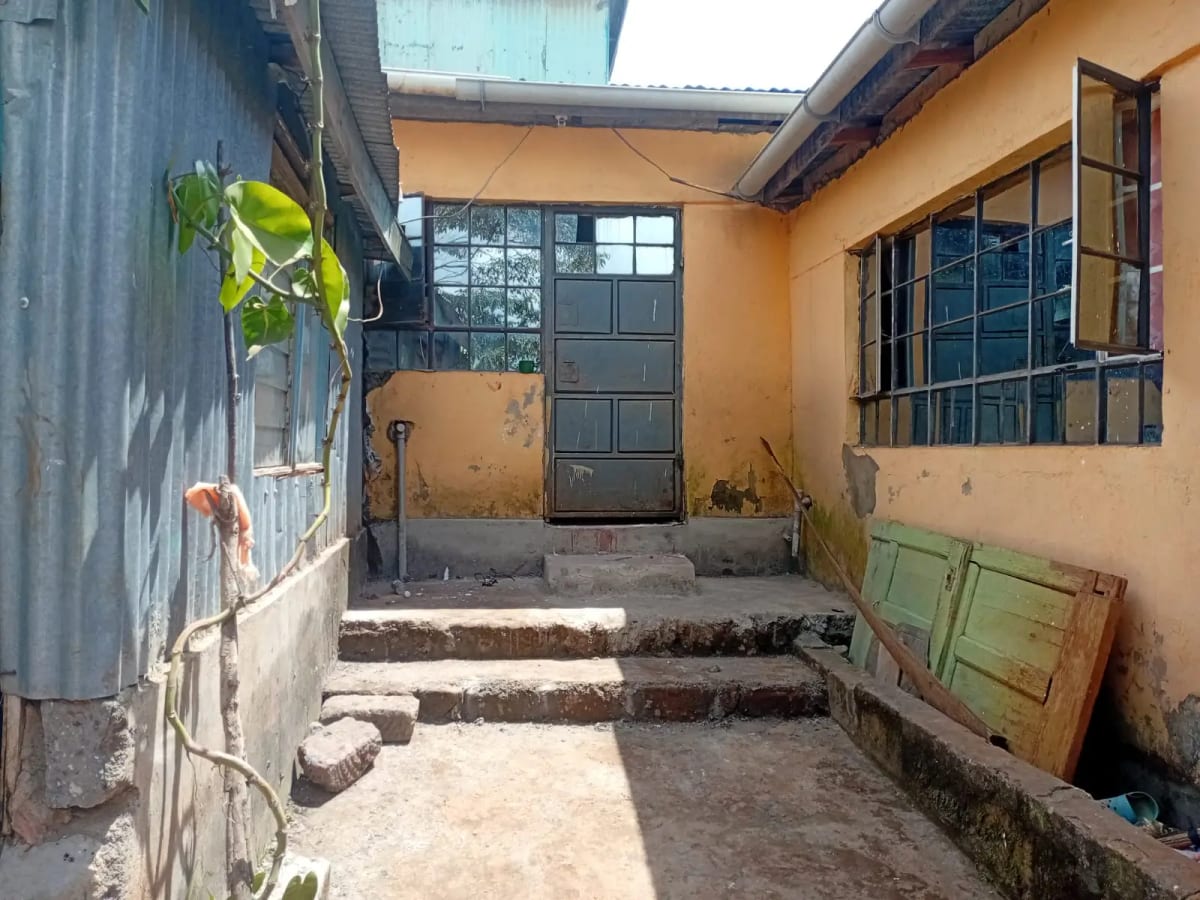 Compound entrance with metal door and orange-painted walls