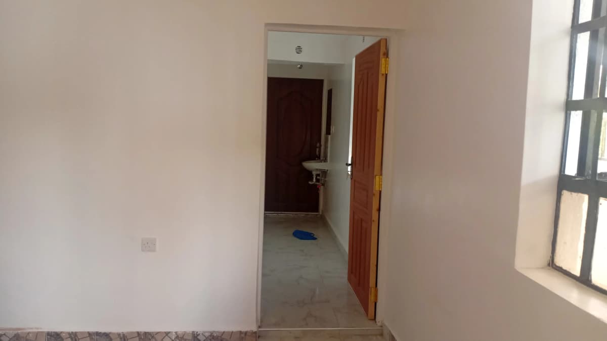 Hallway with open wooden door leading to interior space