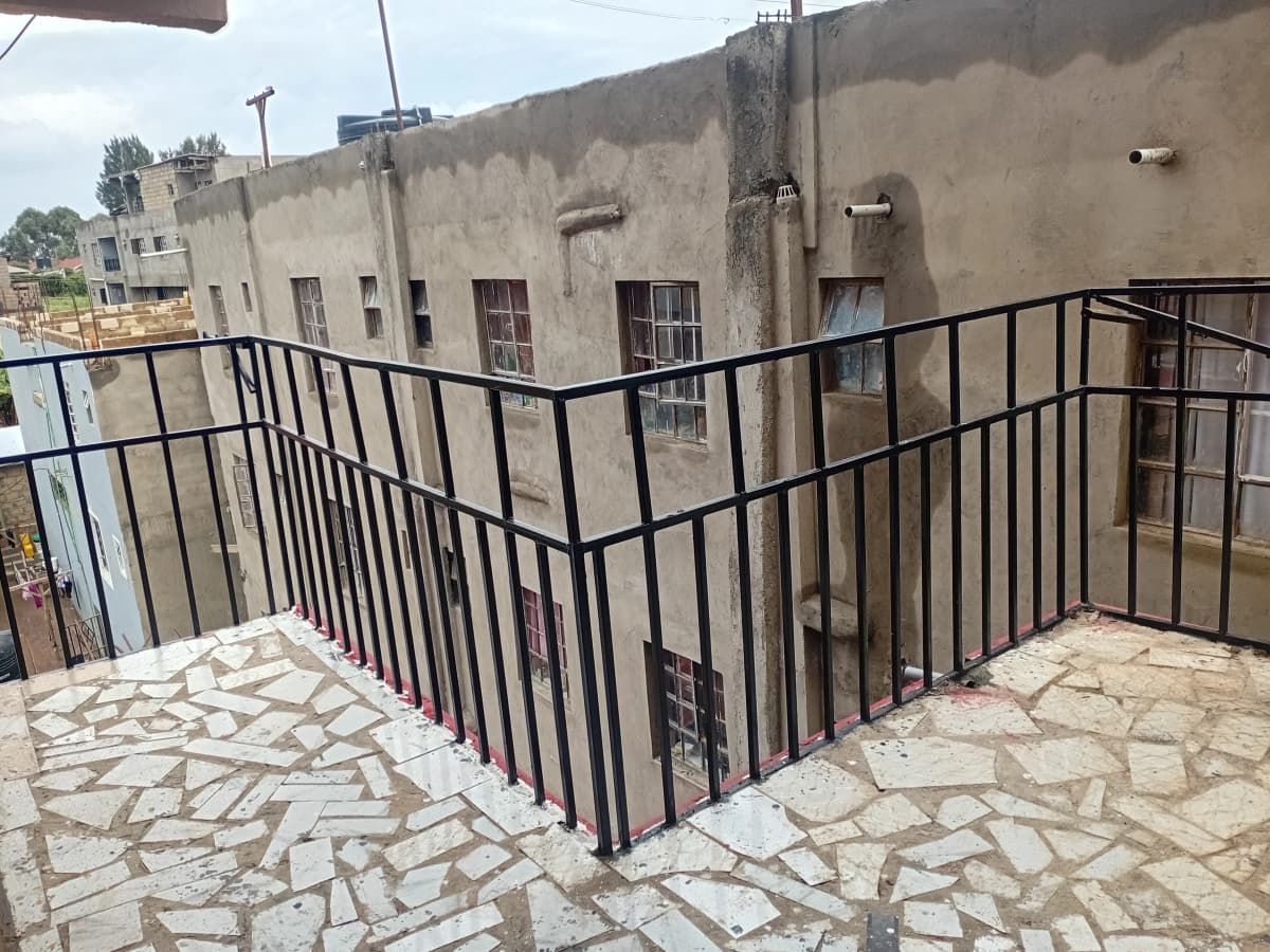 Rooftop terrace with black metal railing and stone flooring