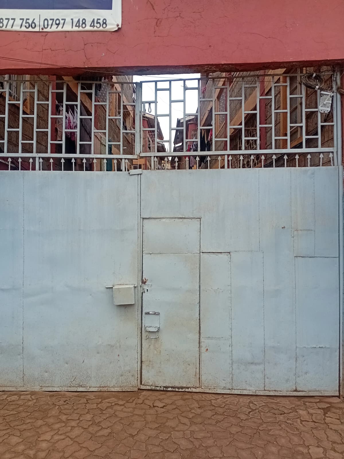 Metal gate entrance with brick wall above