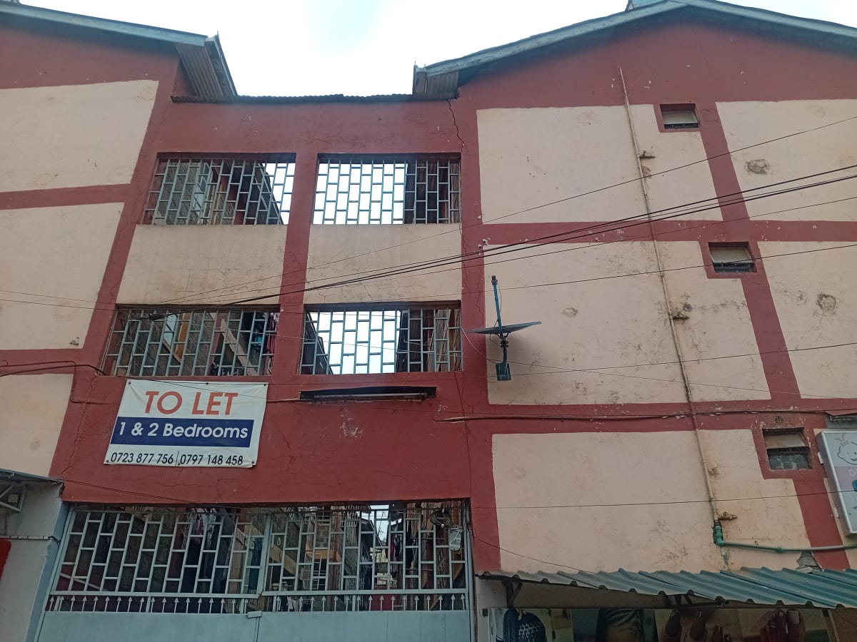 Red and beige apartment building facade with rental signage