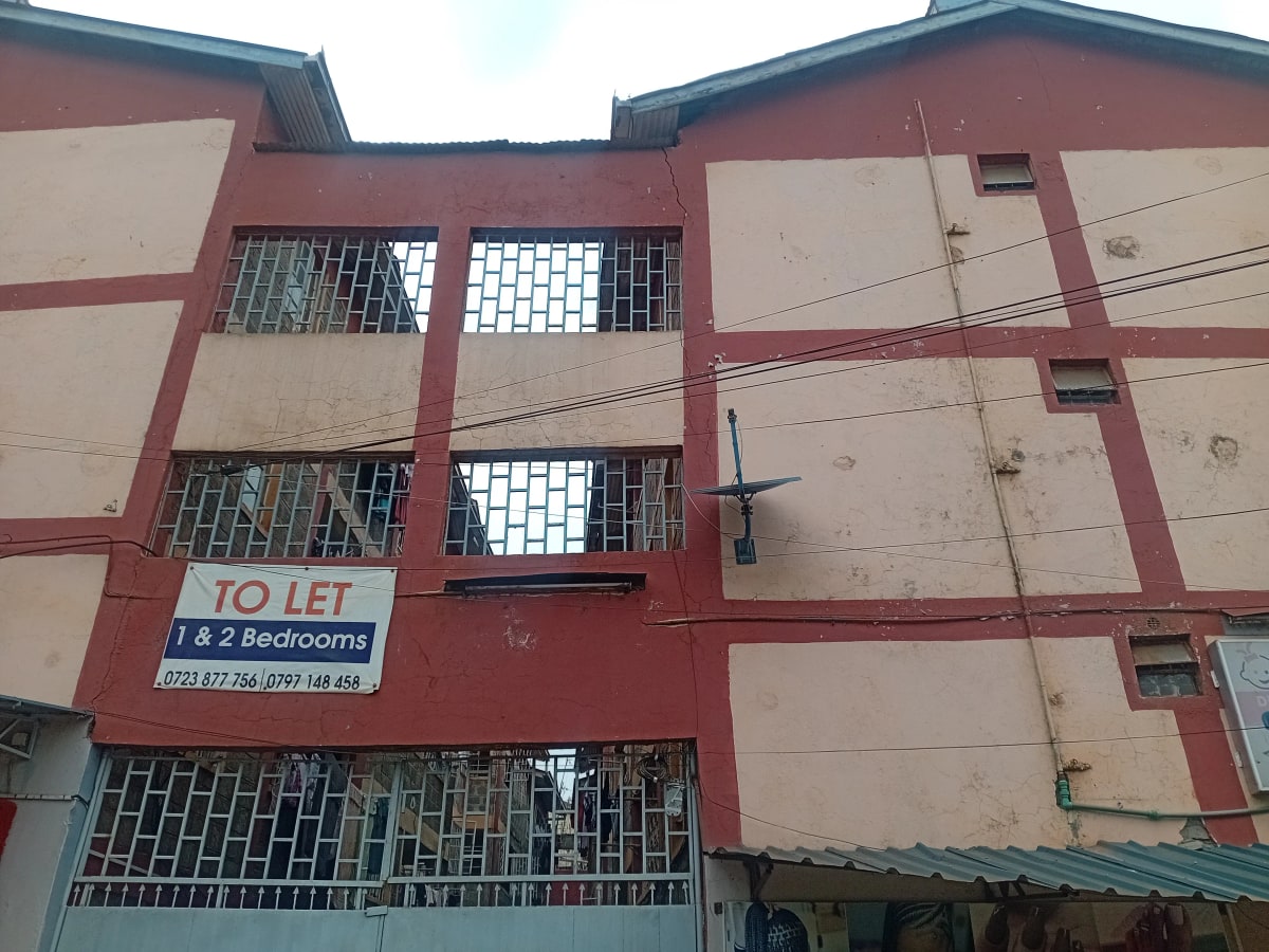 Red and beige apartment building facade with rental signage