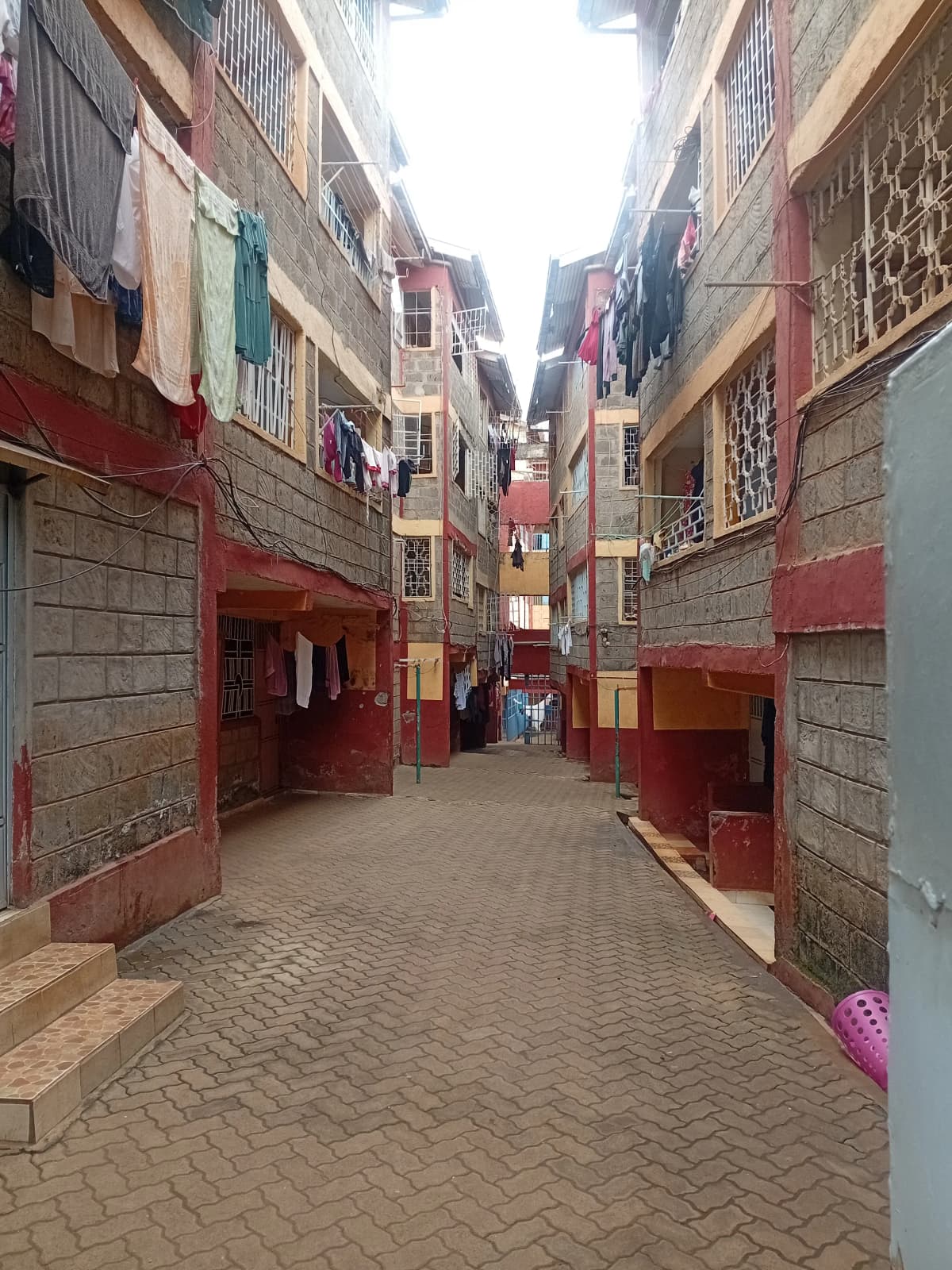 Narrow compound alleyway with residential buildings and clotheslines