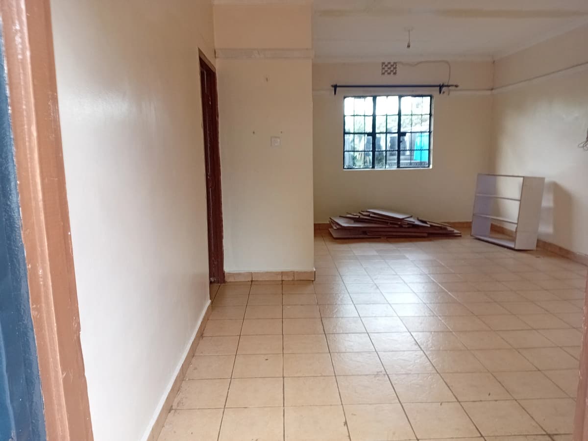 Spacious empty living room with tile flooring and window.