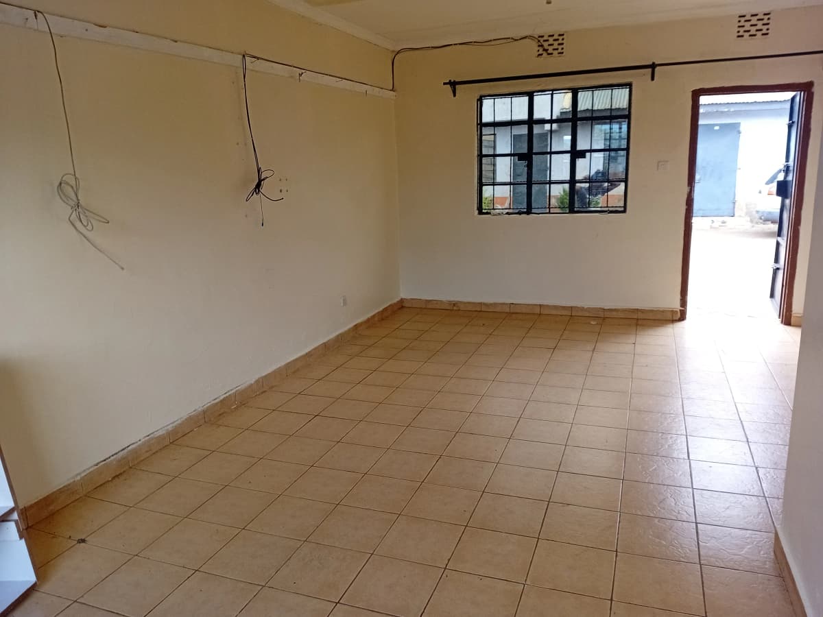 Empty living room with terracotta tiles and bright windows