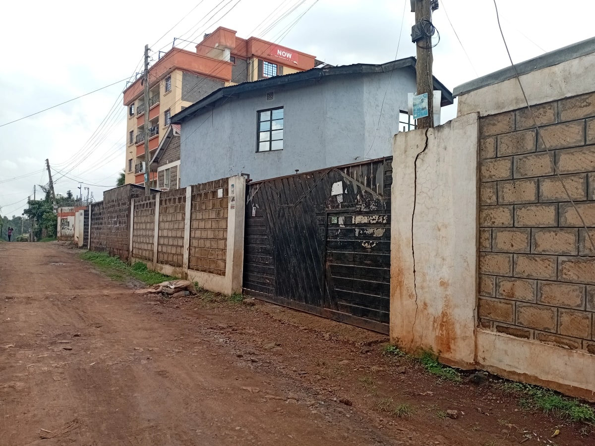 Compound entrance with metal gate and brick walls