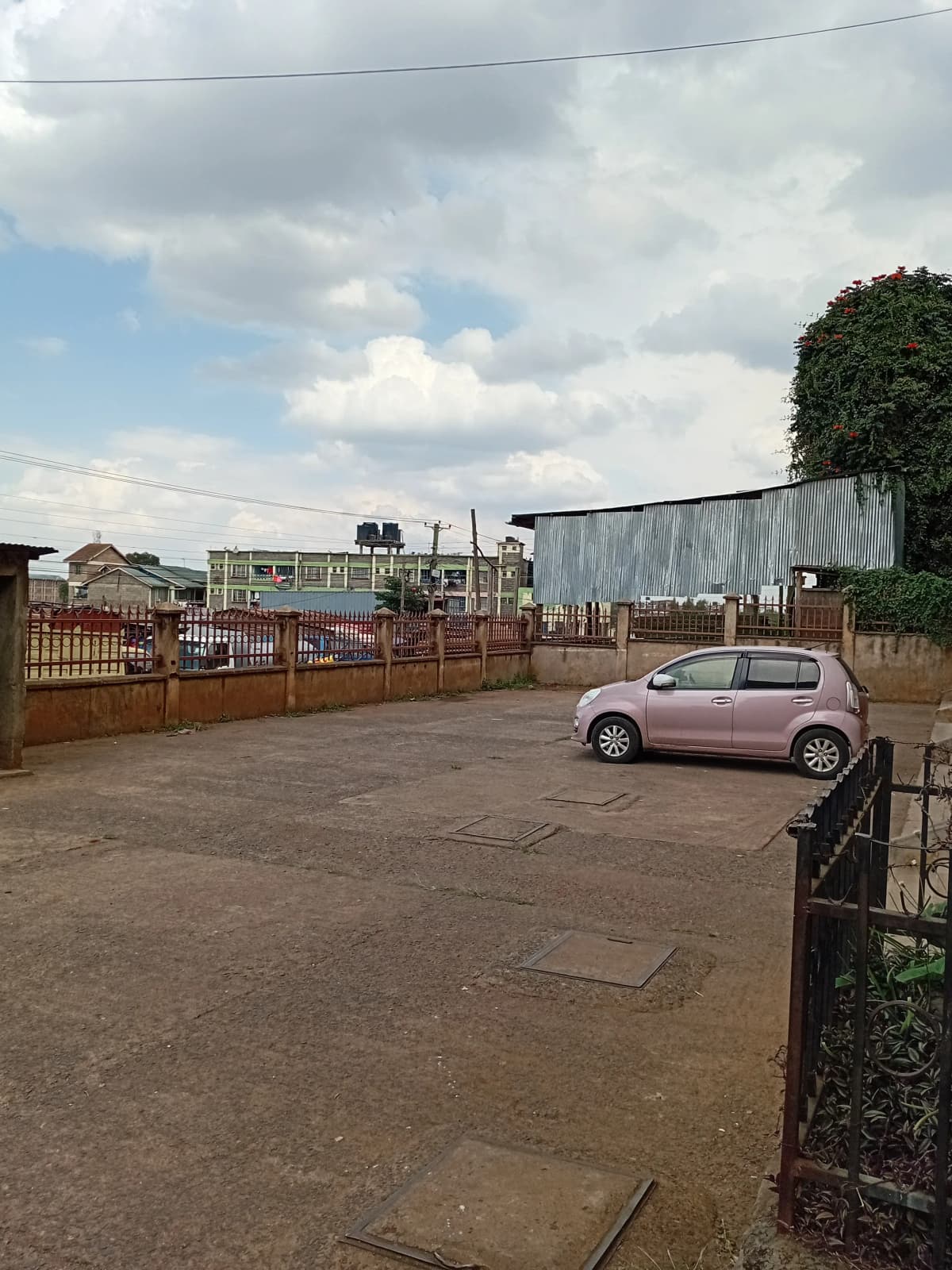 Paved parking area with single vehicle and metal gates
