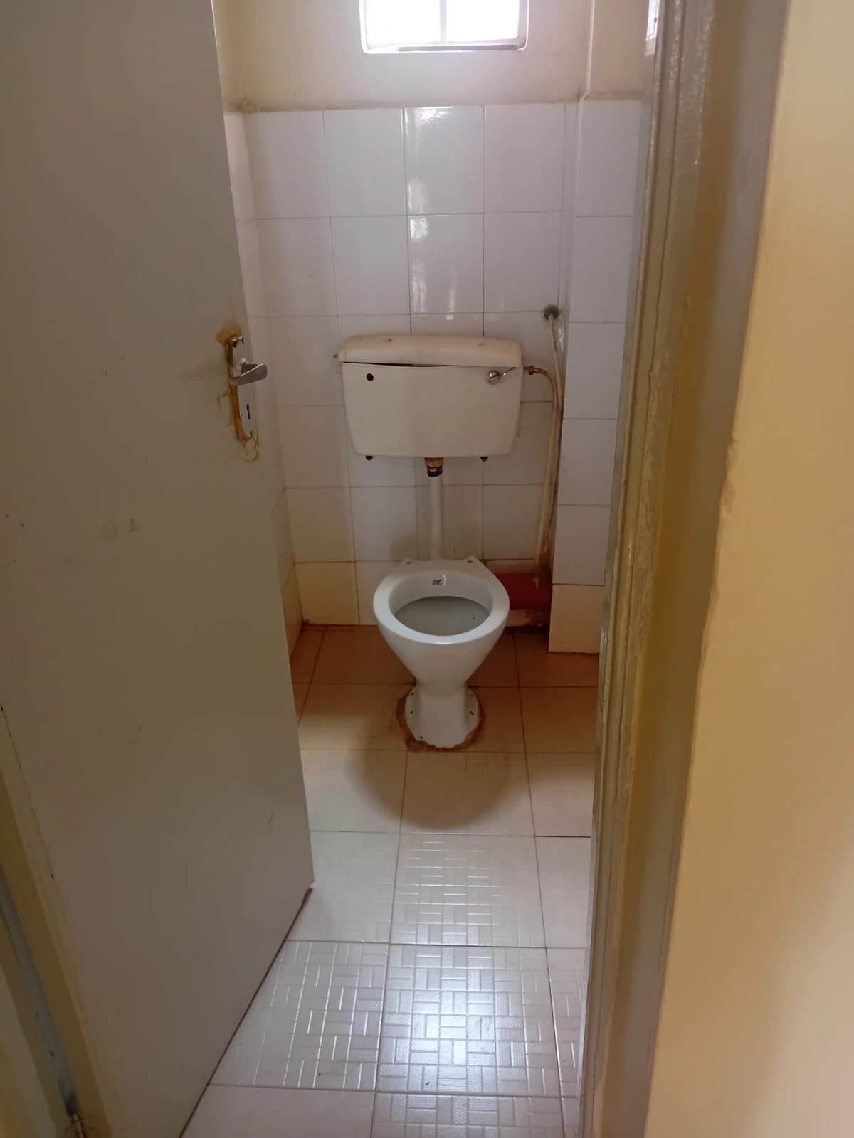 Simple bathroom with white tile walls and basic fixtures