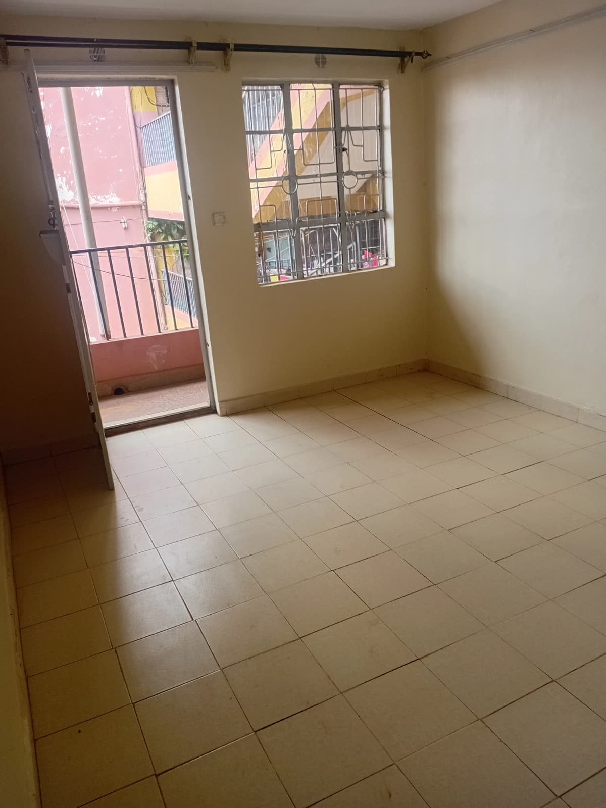 Spacious living room with tiled floor and balcony access