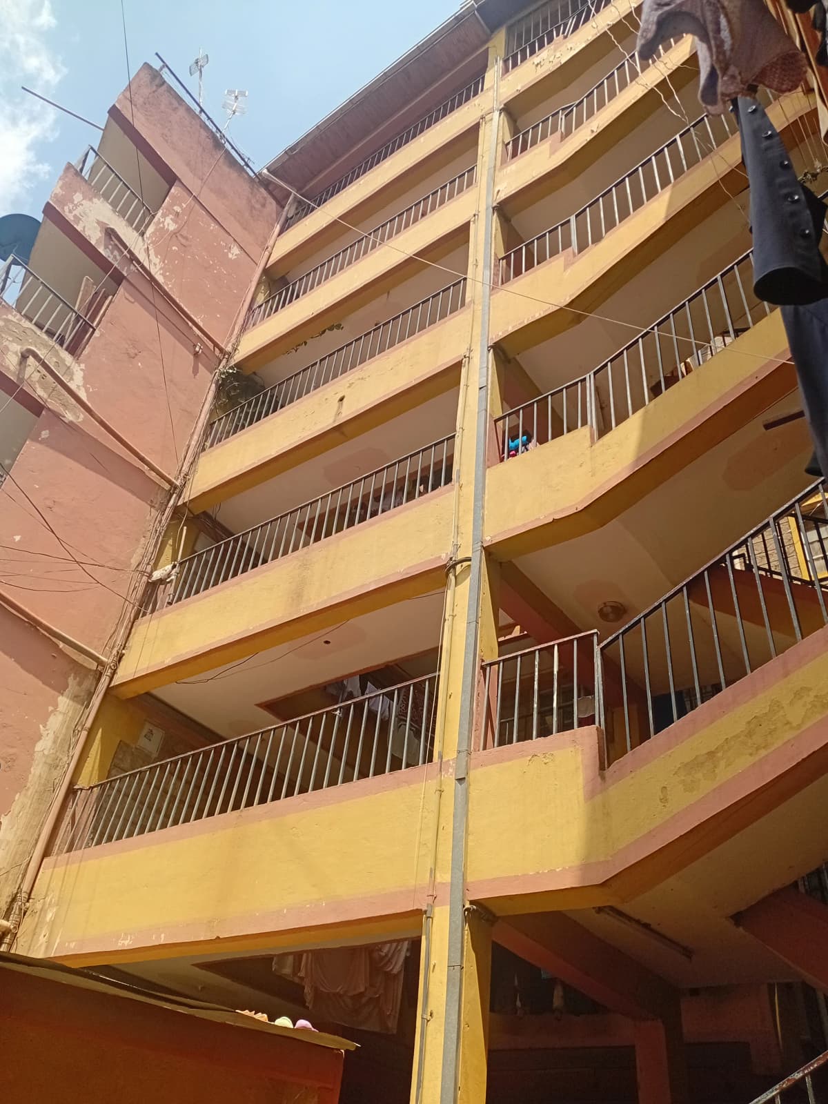 Multi-story yellow apartment building facade with balconies