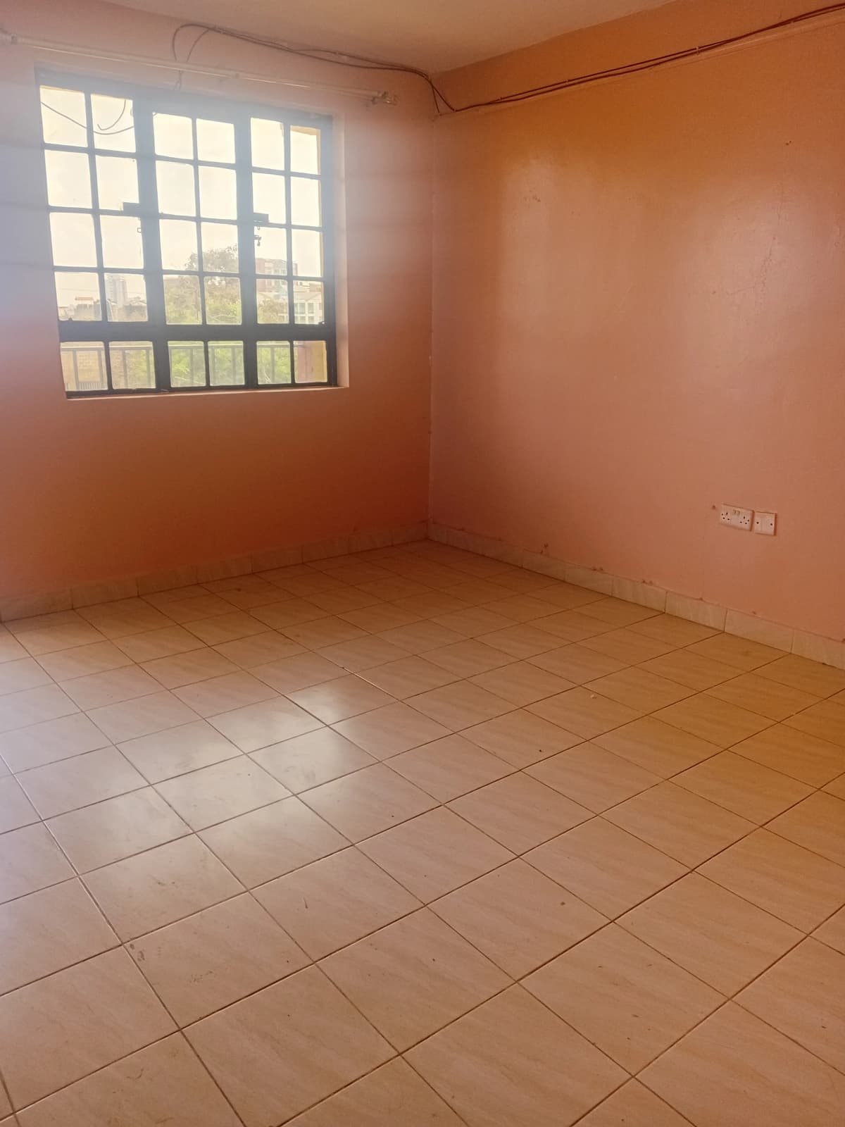 Empty bedroom with terracotta walls and tiled flooring
