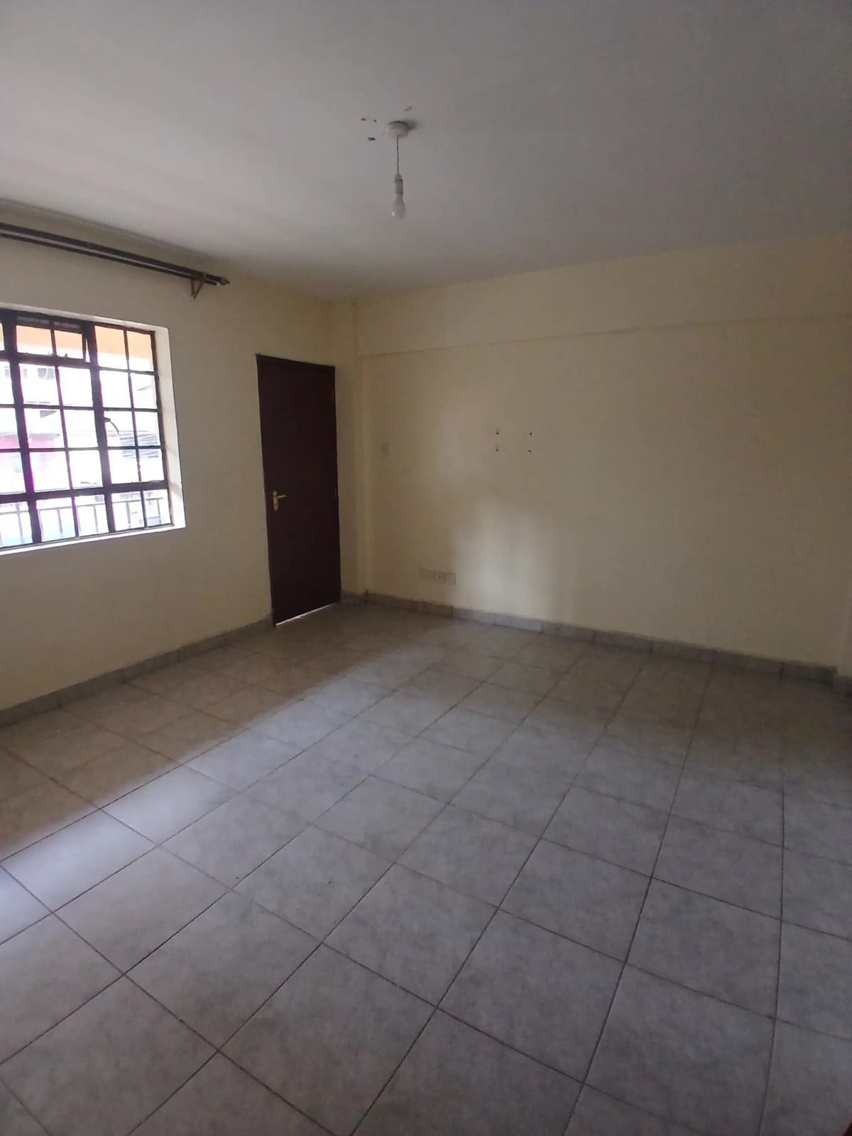 Empty living room with tiled floor and window