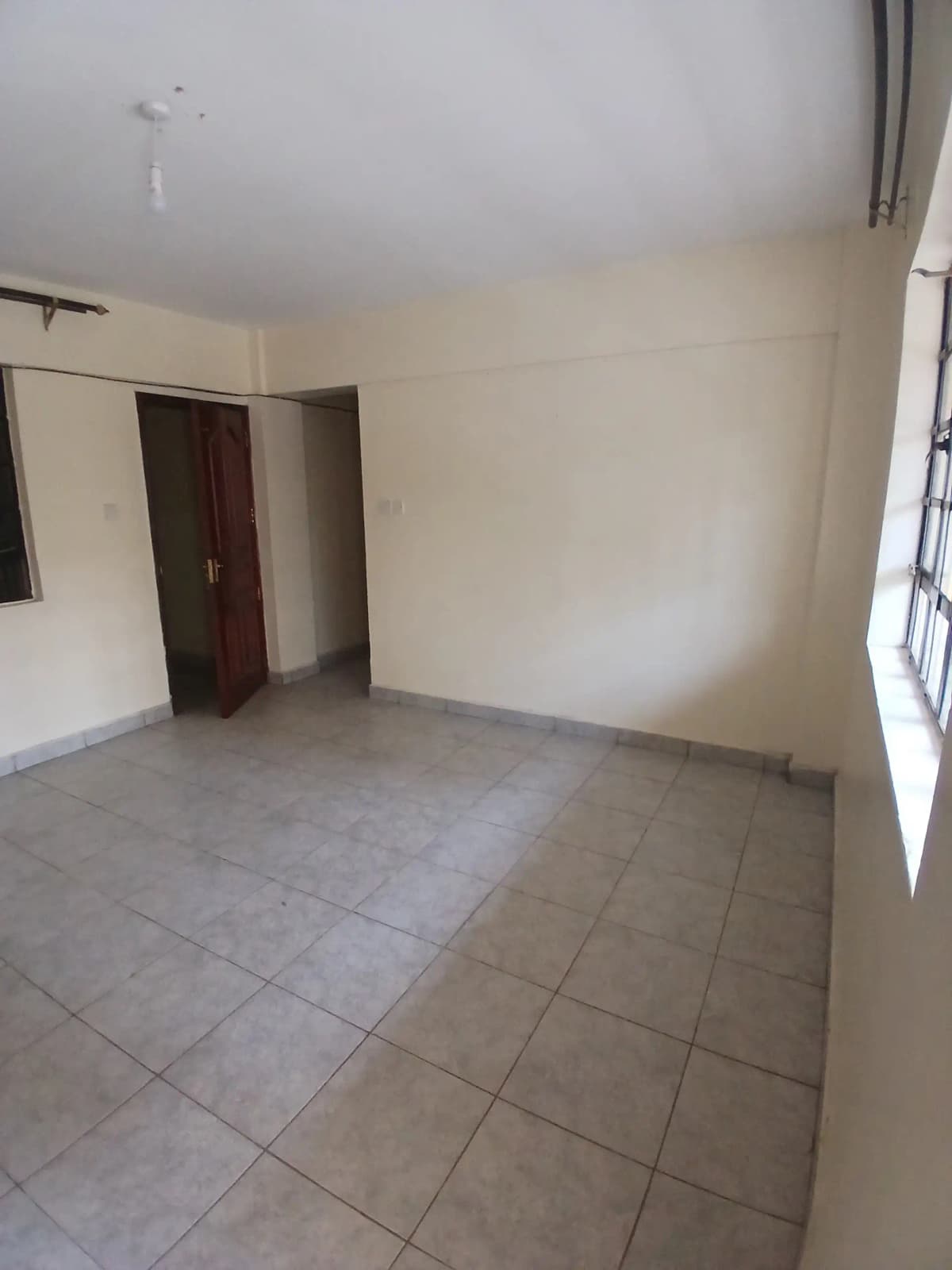 Unfurnished bedroom with tiled floor and dark wooden door