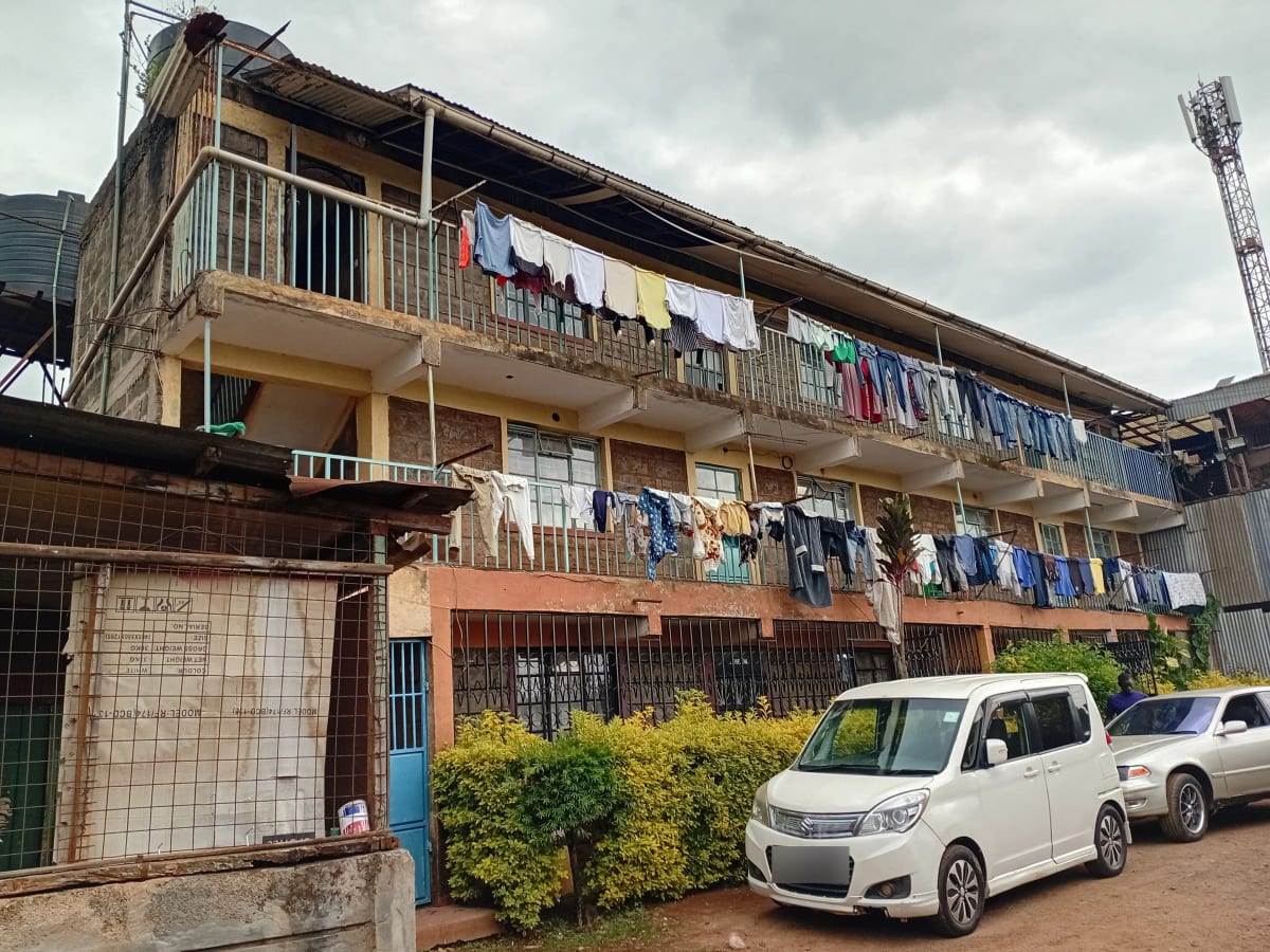 Multi-story residential building facade with laundry and parking