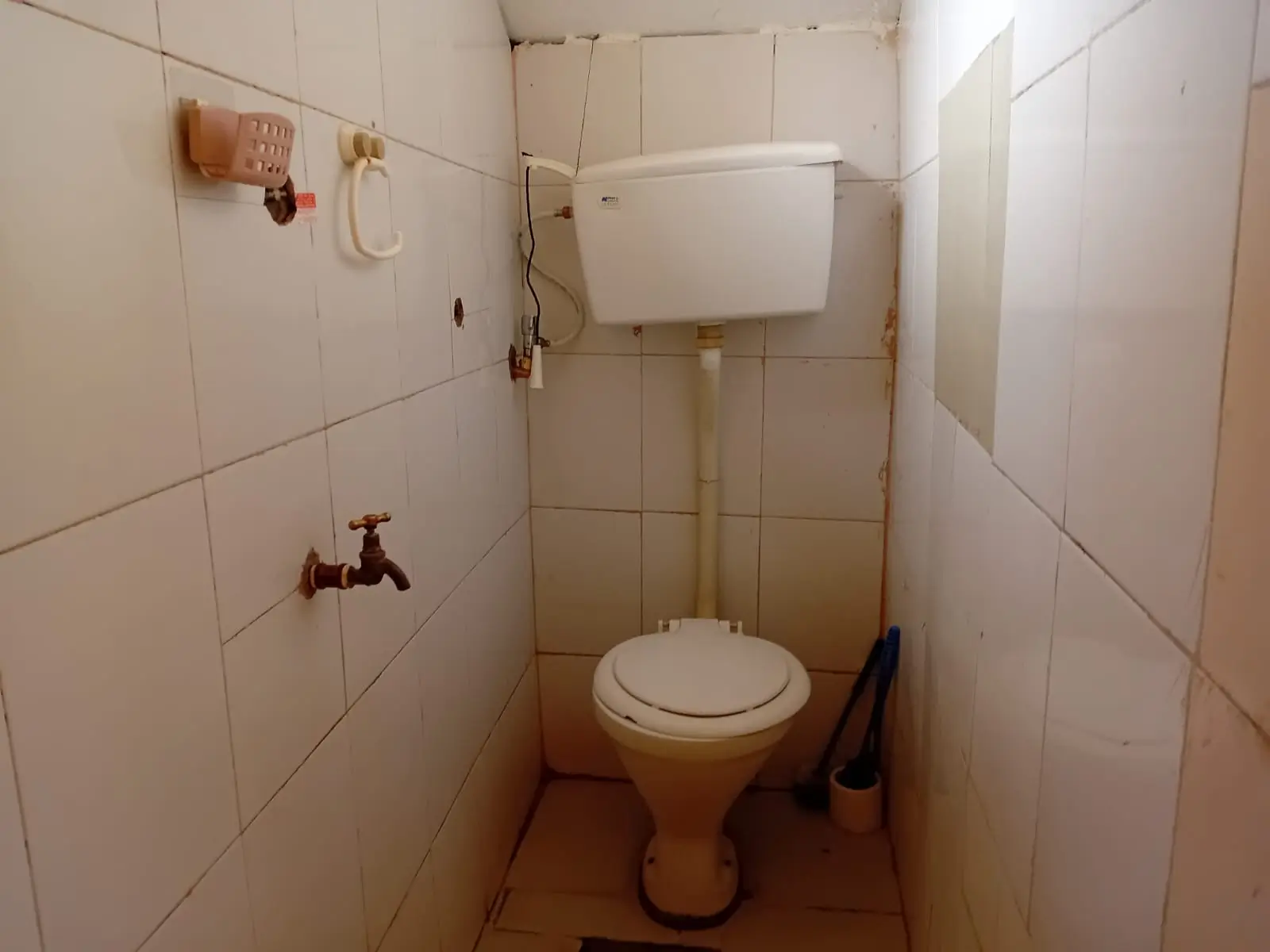 Small toilet room with wall-mounted cistern and basic fixtures