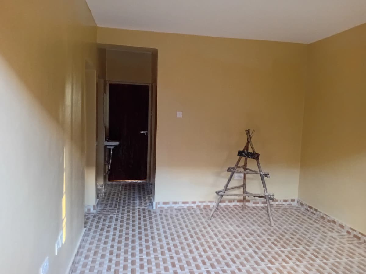 Empty living room with yellow walls, geometric tile flooring