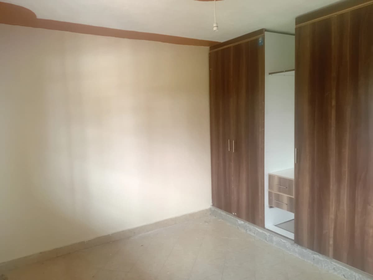 Spacious bedroom with wooden wardrobes and mirror panel