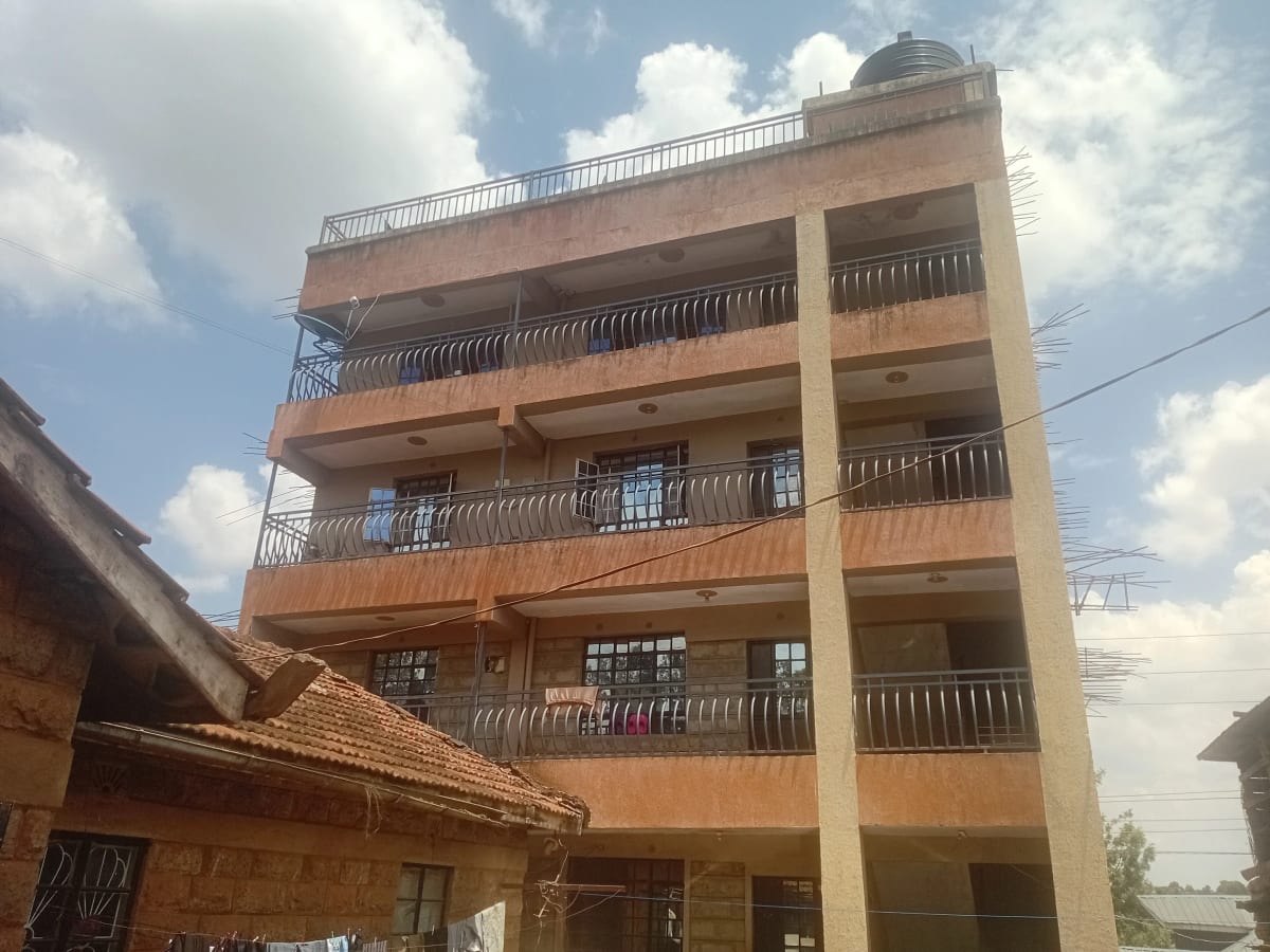 Multi-story residential building with terracotta facade and balconies