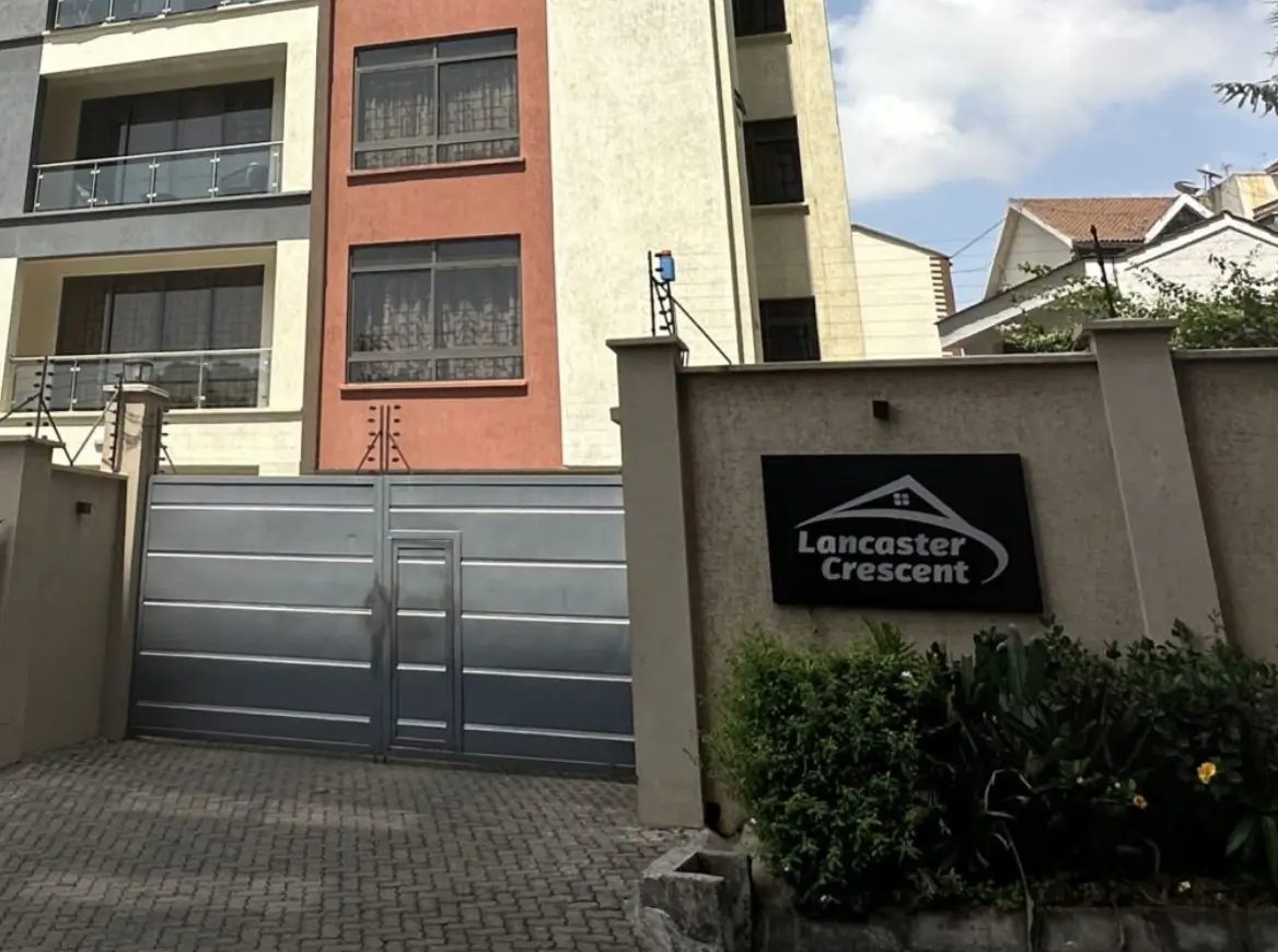 Modern apartment building facade with gray driveway gate