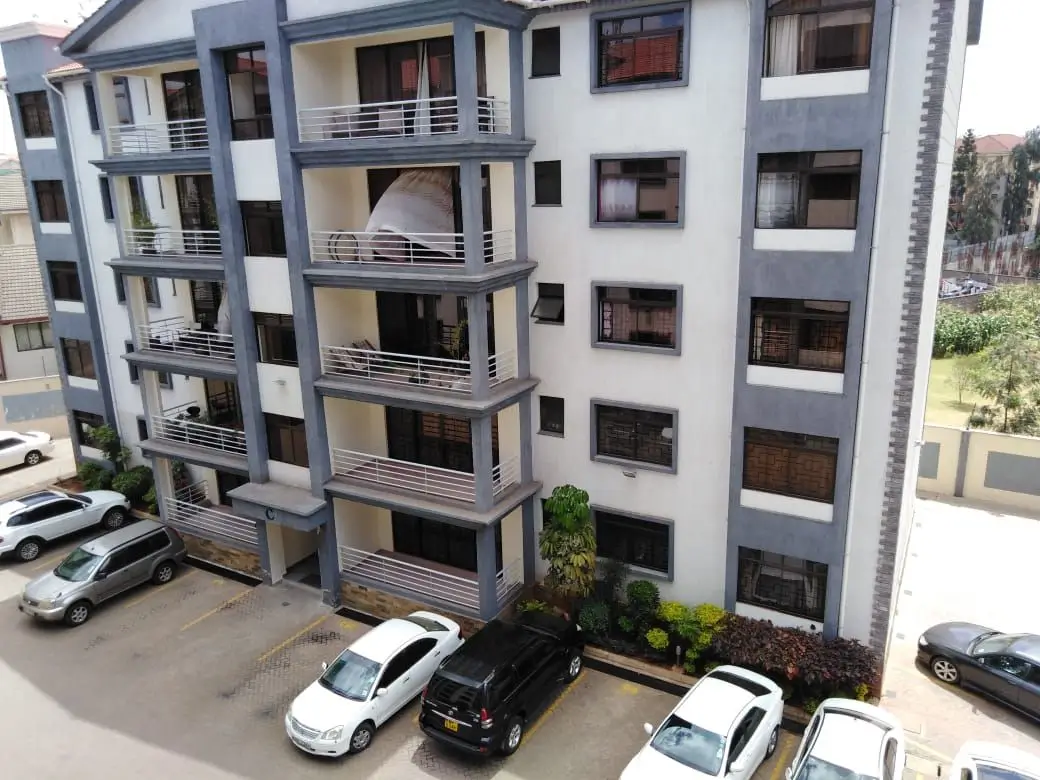 Modern multi-story residential building with balconies and parking