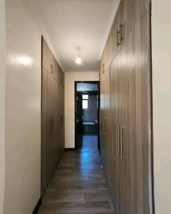 Modern corridor with built-in wardrobes and polished flooring
