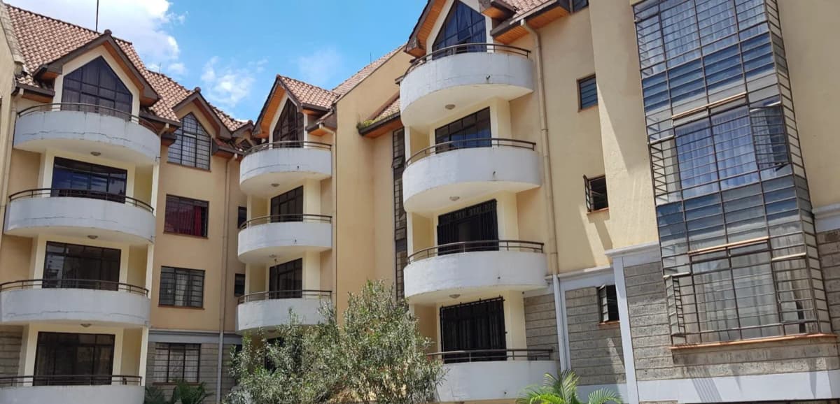 Multi-story residential building with cream facade and curved balconies