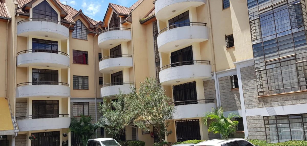 Multi-story residential building with curved balconies and landscaping