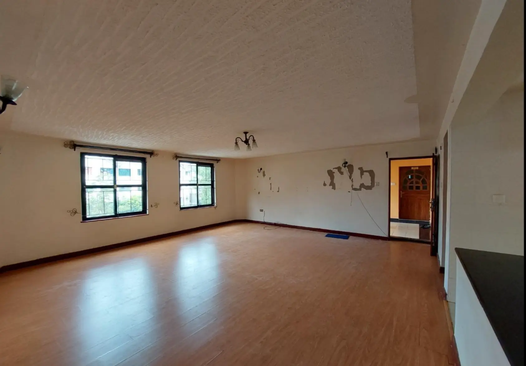 Spacious empty living room with wooden floors and natural light