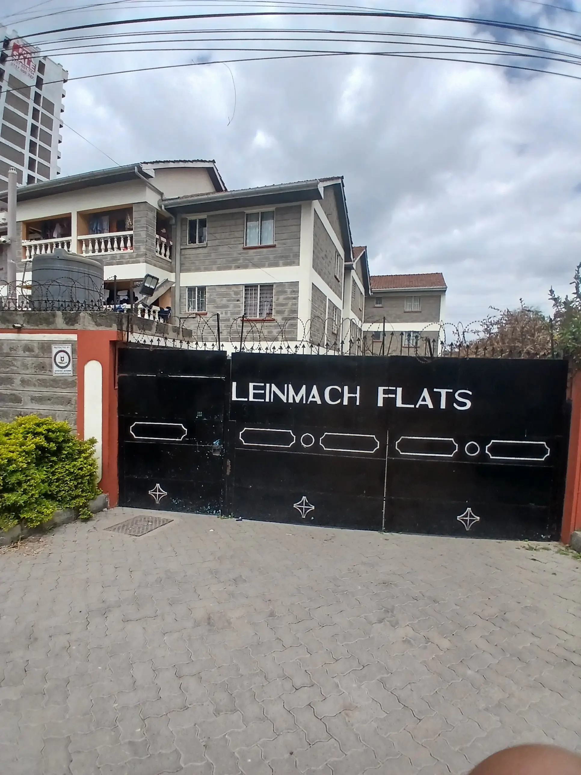 Lenmach Flats compound entrance with black decorative gate