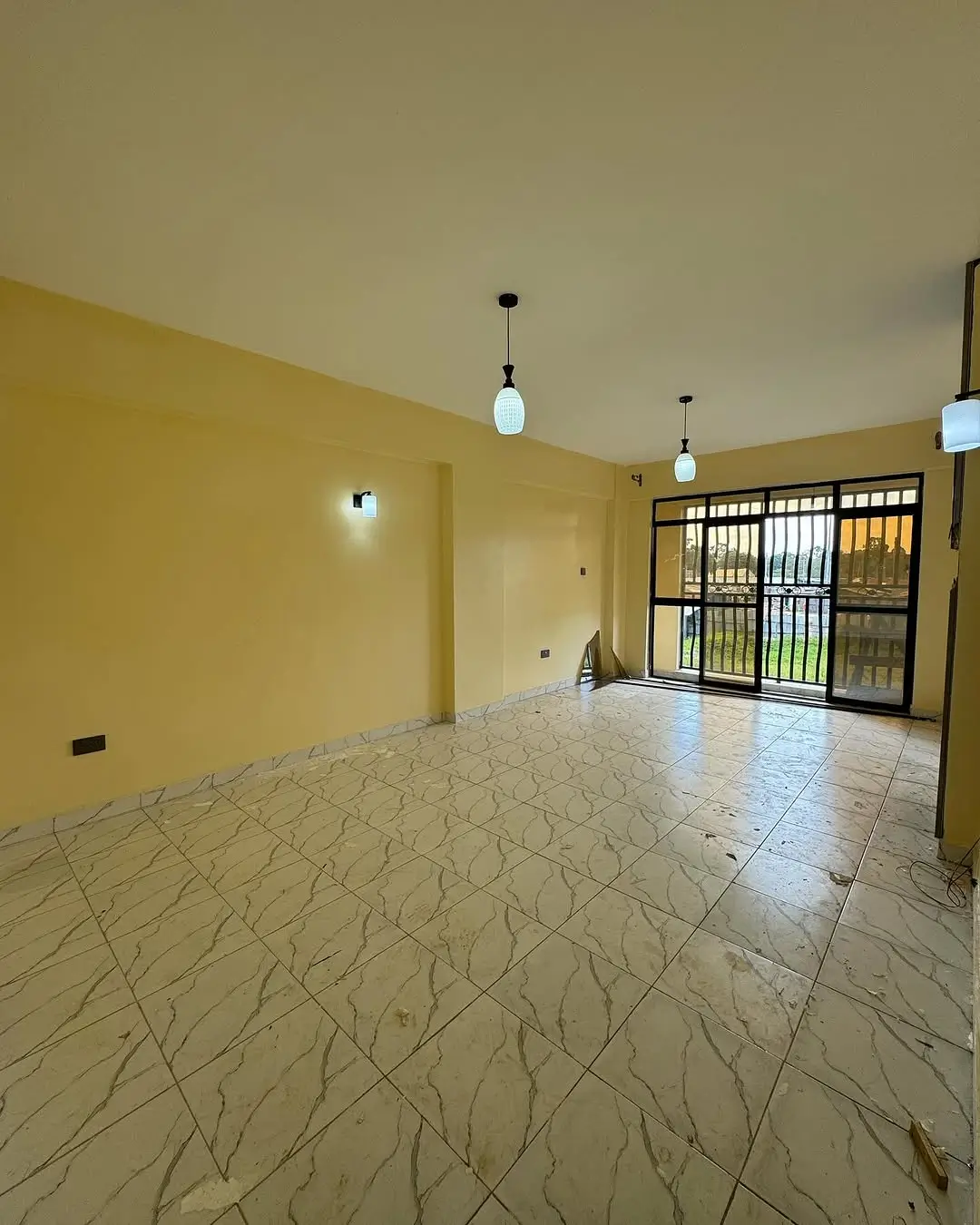 Spacious living room with yellow walls and decorative tile flooring