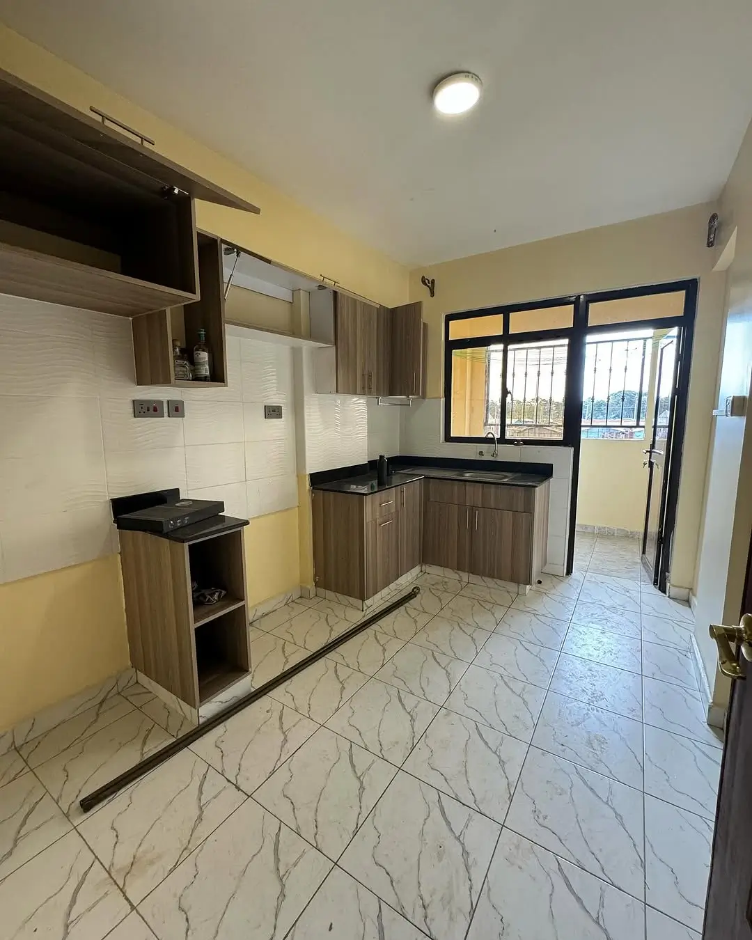 Modern kitchen with wooden cabinetry and marble-effect flooring