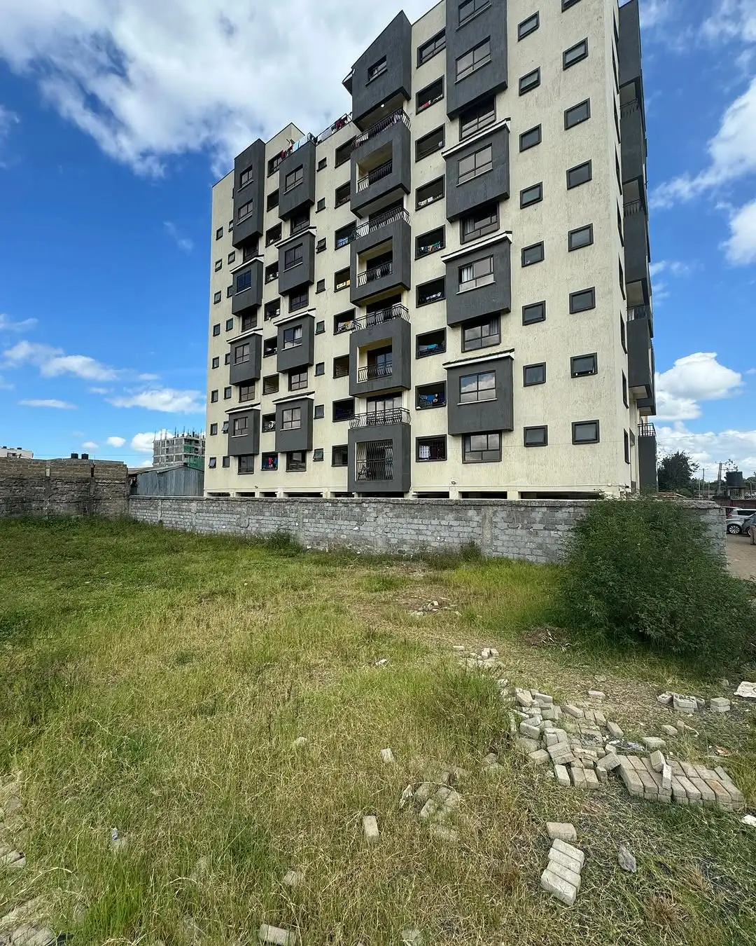 Multi-story residential building facade with landscaped grounds