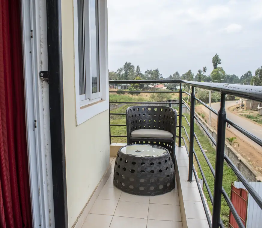 Balcony with seating, rural landscape view, metal railing